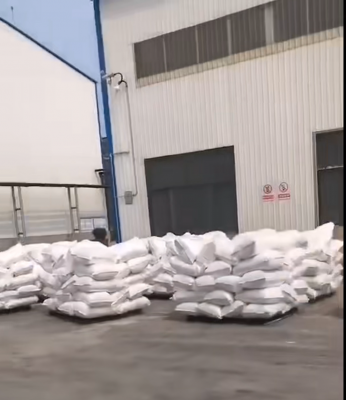 工人正在操作吸水树脂装车，工厂厂区生产线